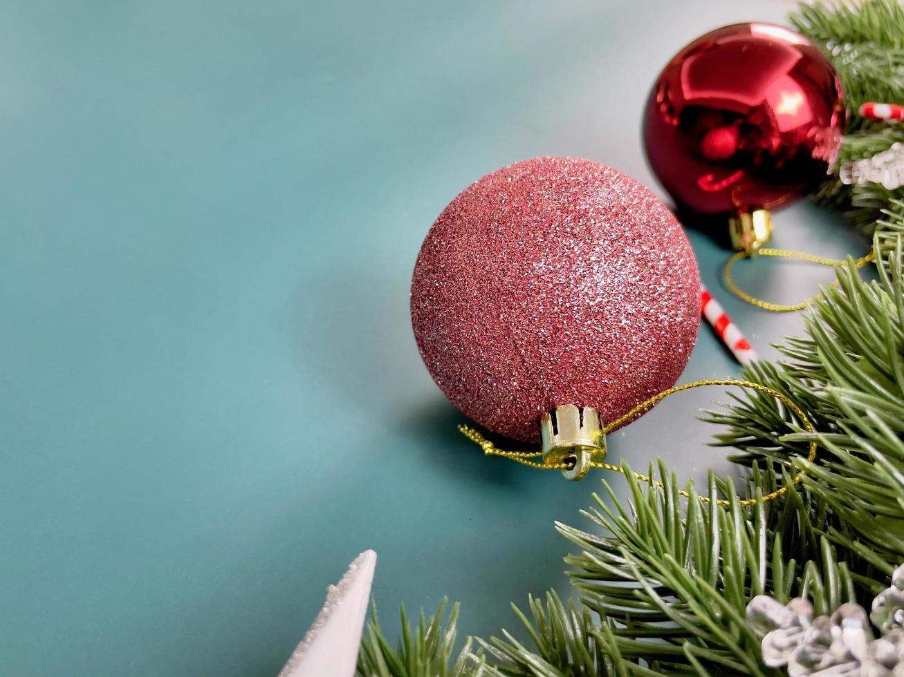 adornos navideños, hojas de pino, bolas rojas, copos de nieve, frutos rojos sobre fondo azul foto