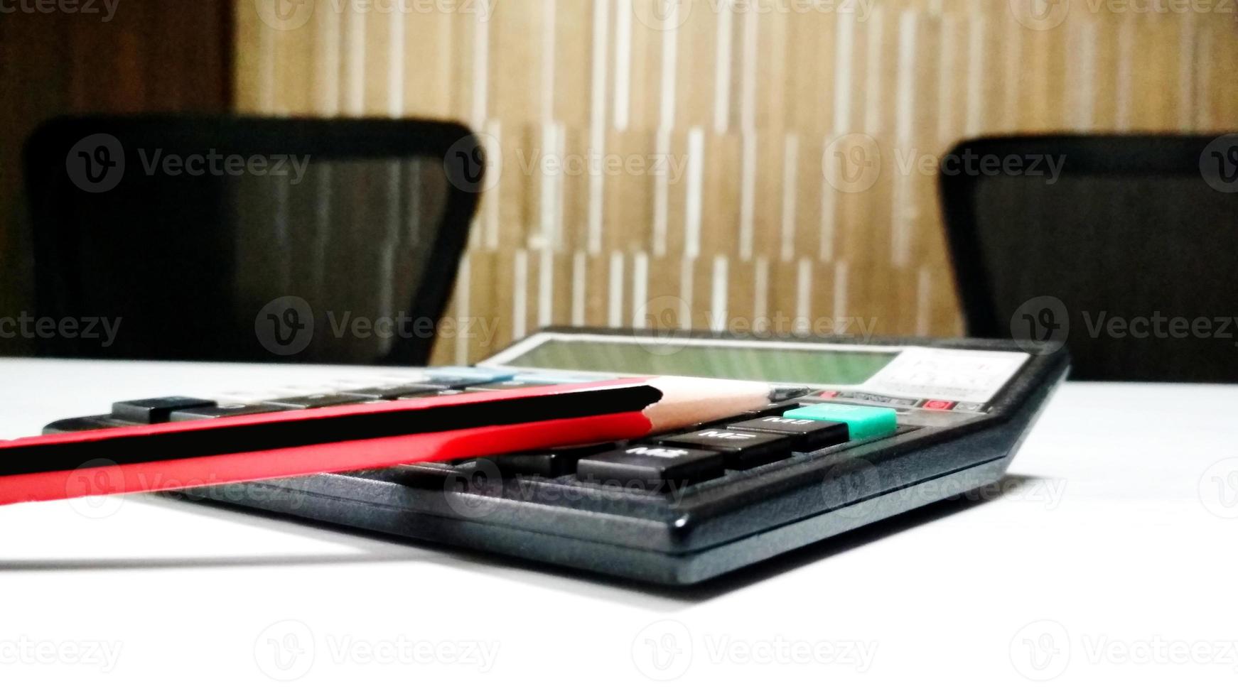 Calculator and pencil in classroom desk photo