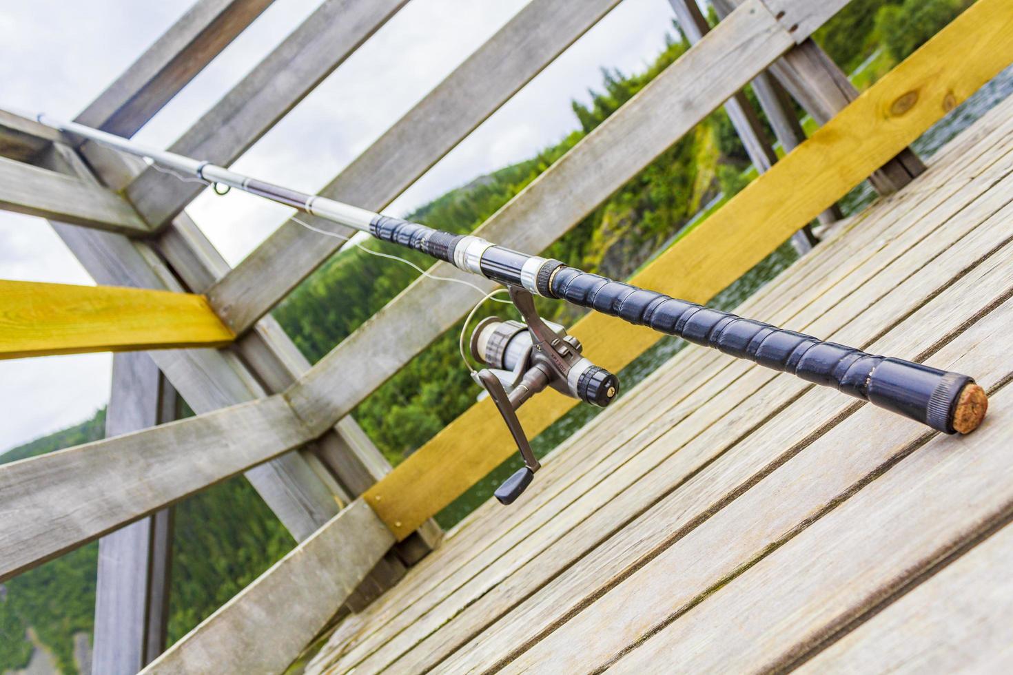 Fishing rod on wooden pier by the lake Vang Norway. photo