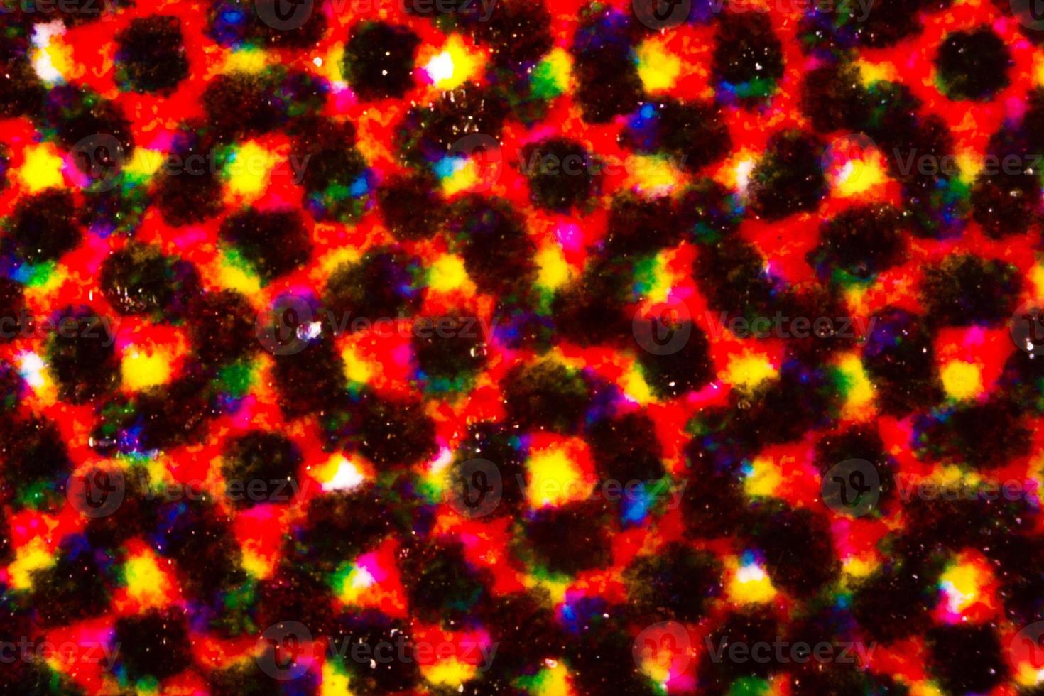 Mancha de tinta abstracta en muchos colores impresos en papel de volante bajo el microscopio foto