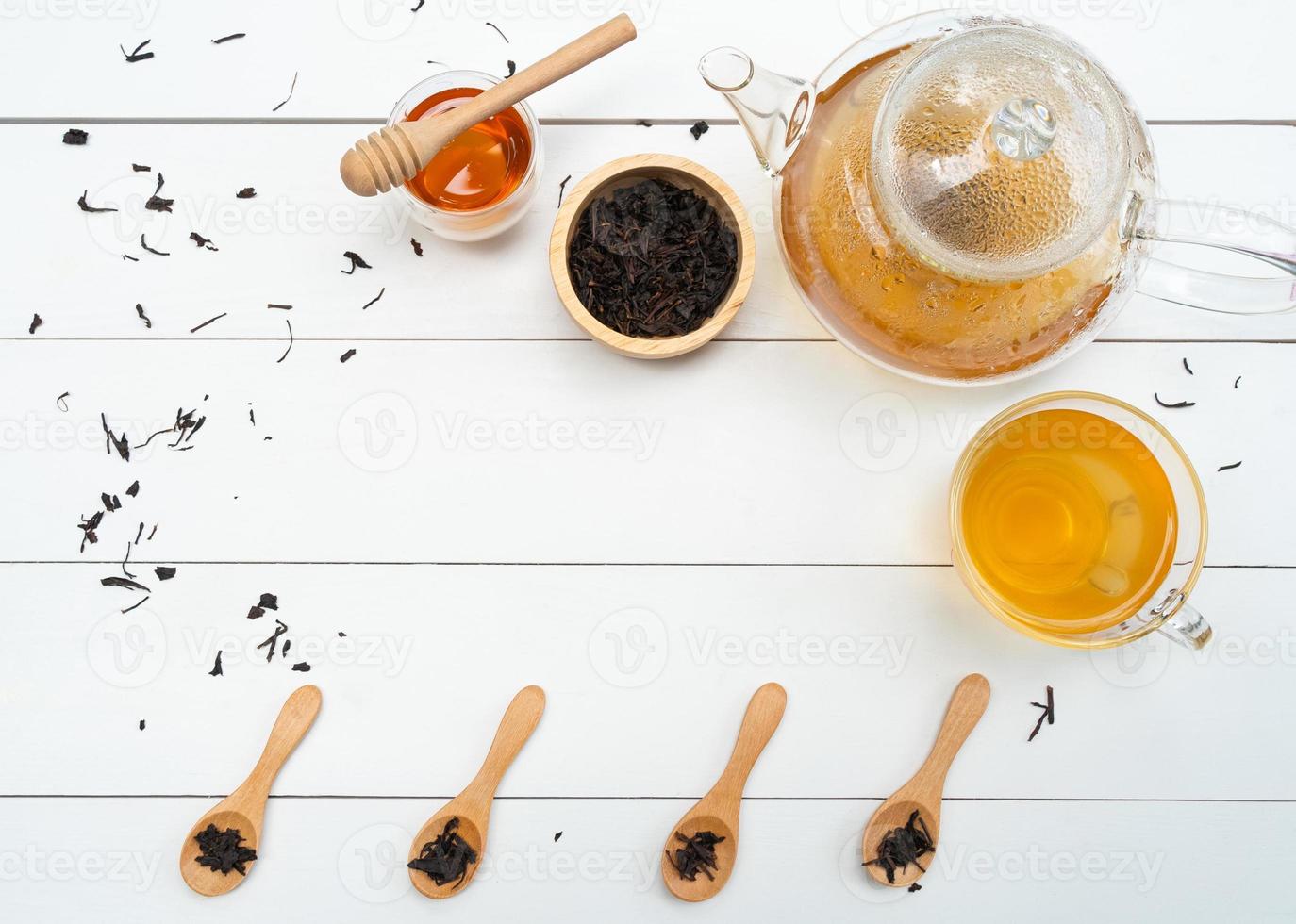 flat lay of hot tea in teapot and cup with honey on whote table photo