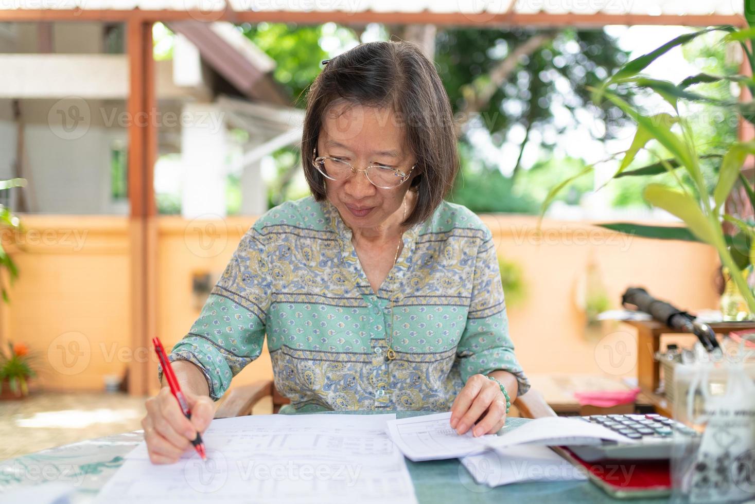 senior asian woman calculate income and expense balance at home terrace photo