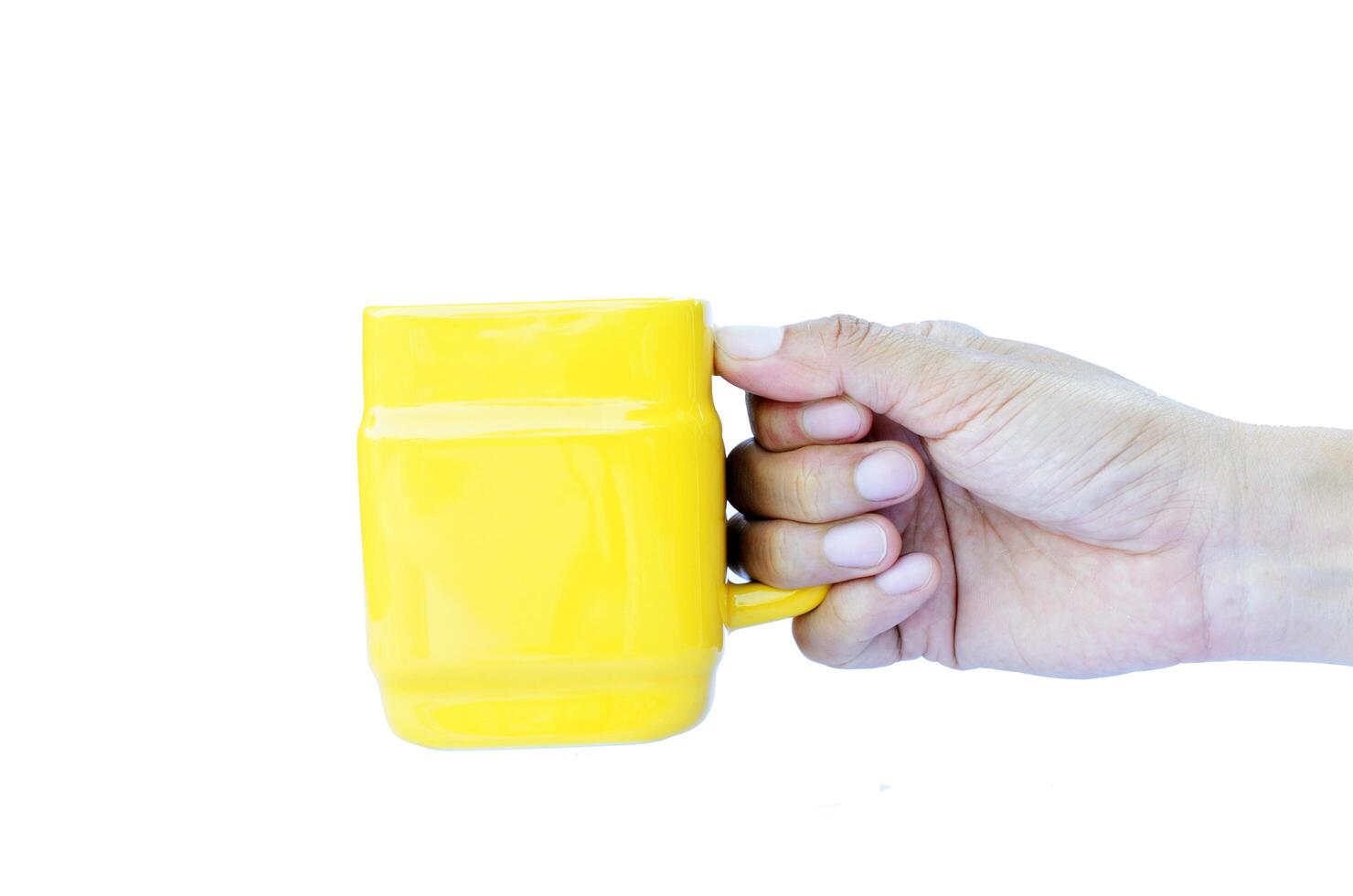 Hand holding Yellow Cups Isolated on white backgrounds photo