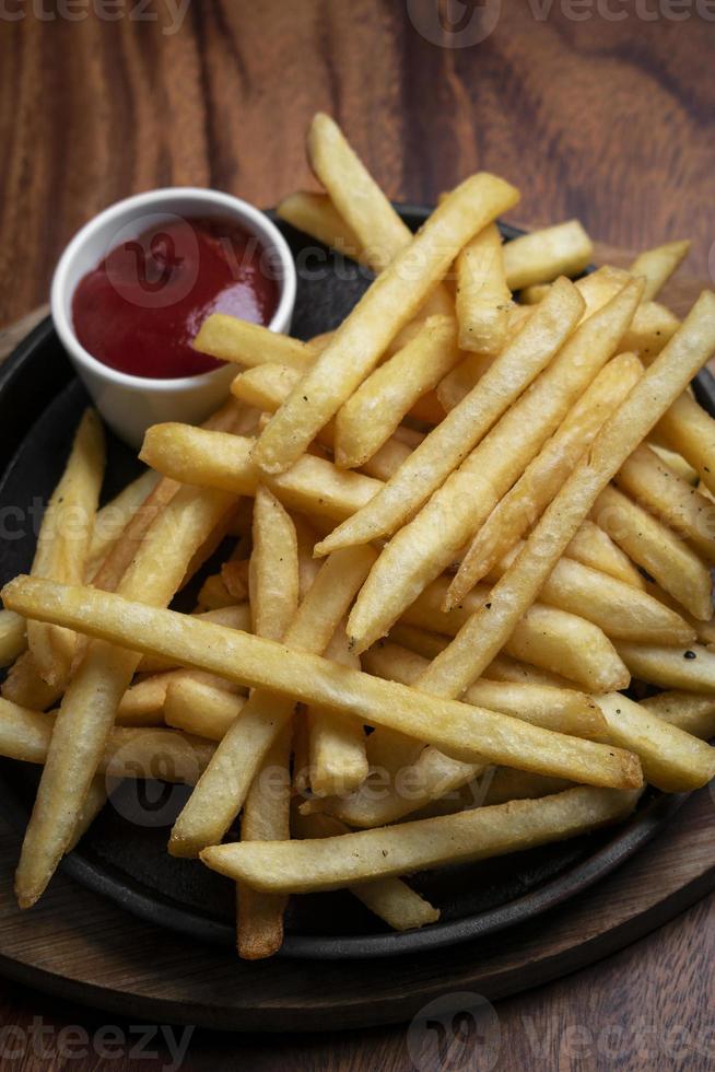 portion of french fries potato snack on wood table background photo