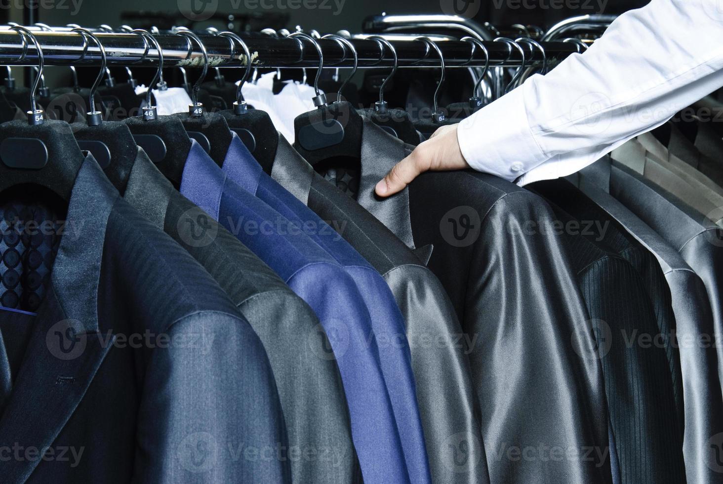 crudo de diferentes colores colgando chaquetas de hombre foto