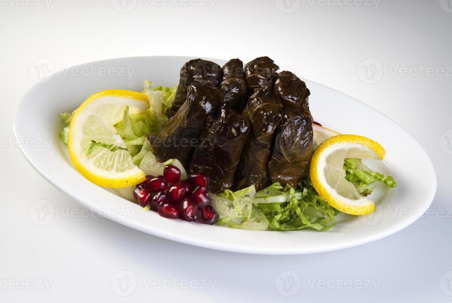 Hojas rellenas de aceite de oliva en el plato con vegetales para servicio de restaurante concepto de Turquía foto