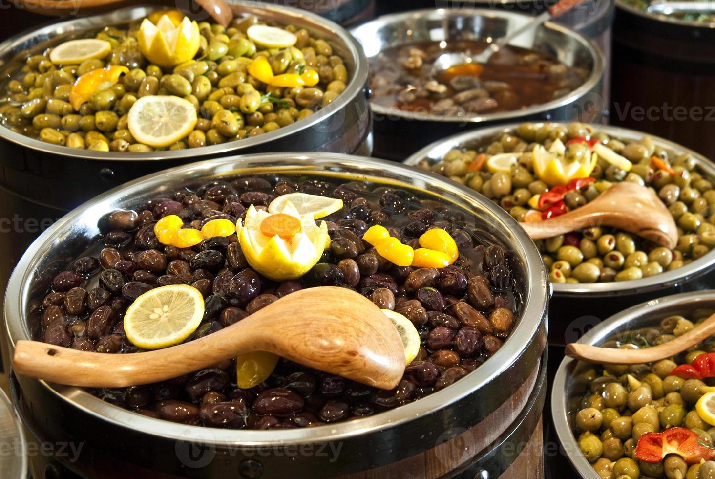 Range of different kinds olives arranged in wooden barrels photo