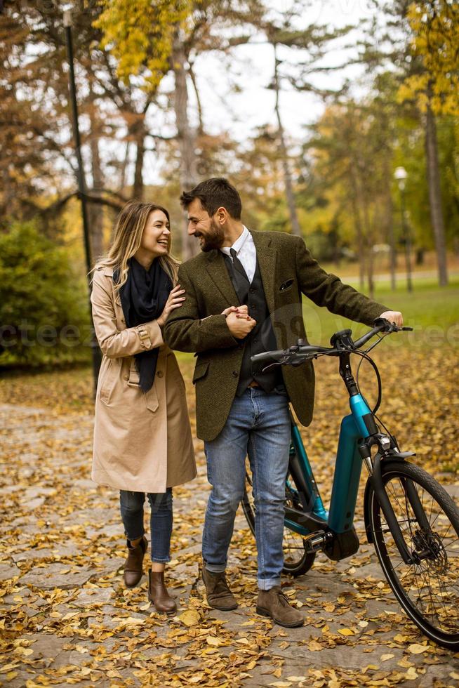 pareja joven, en, el, otoño, parque, con, bicicleta eléctrica foto