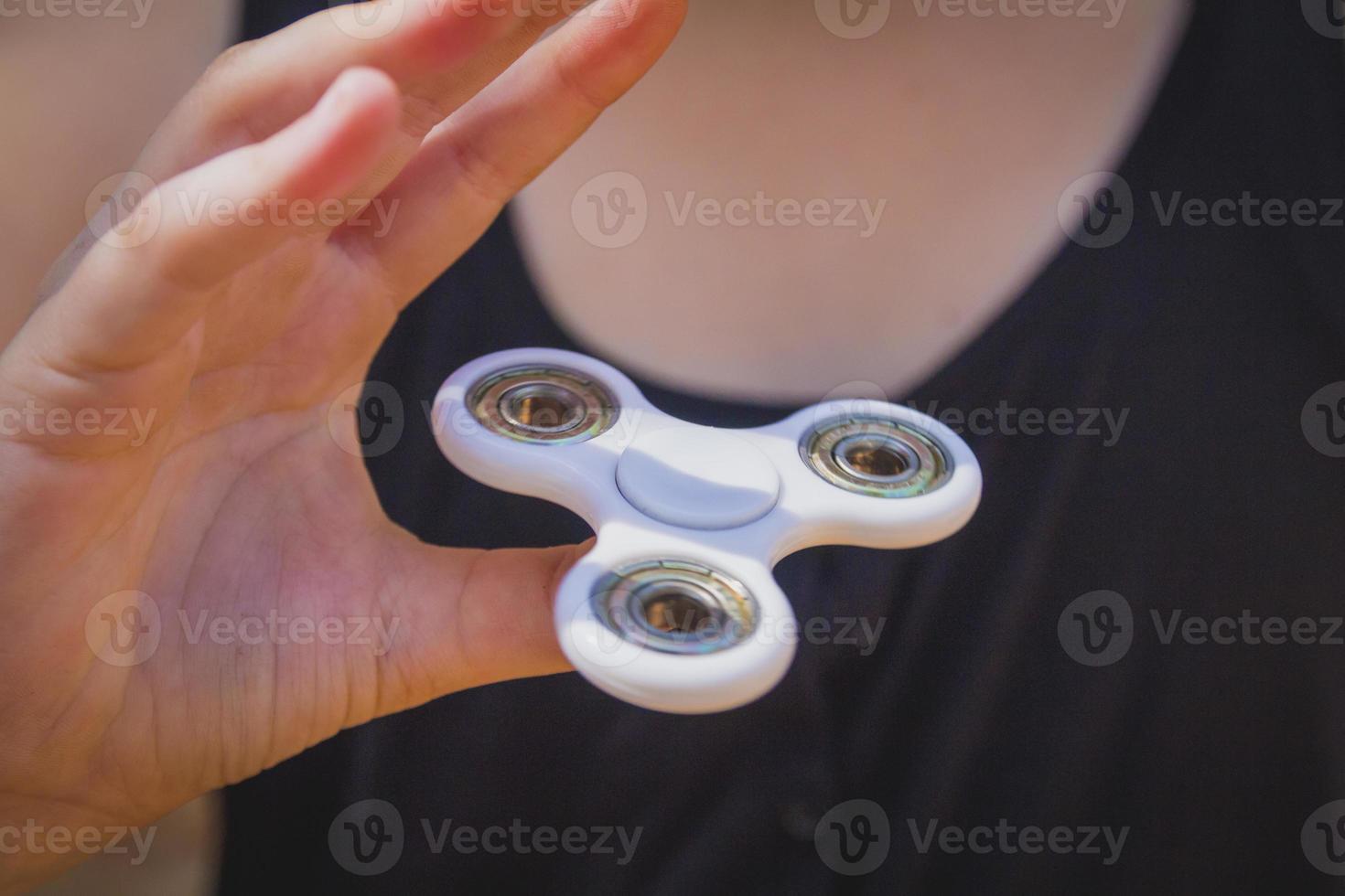 Young girl play with fidget spinner photo