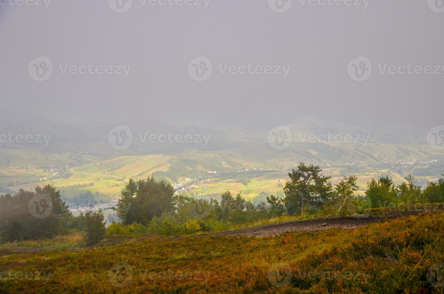 View of village covered in fog at Carpathian mountains photo
