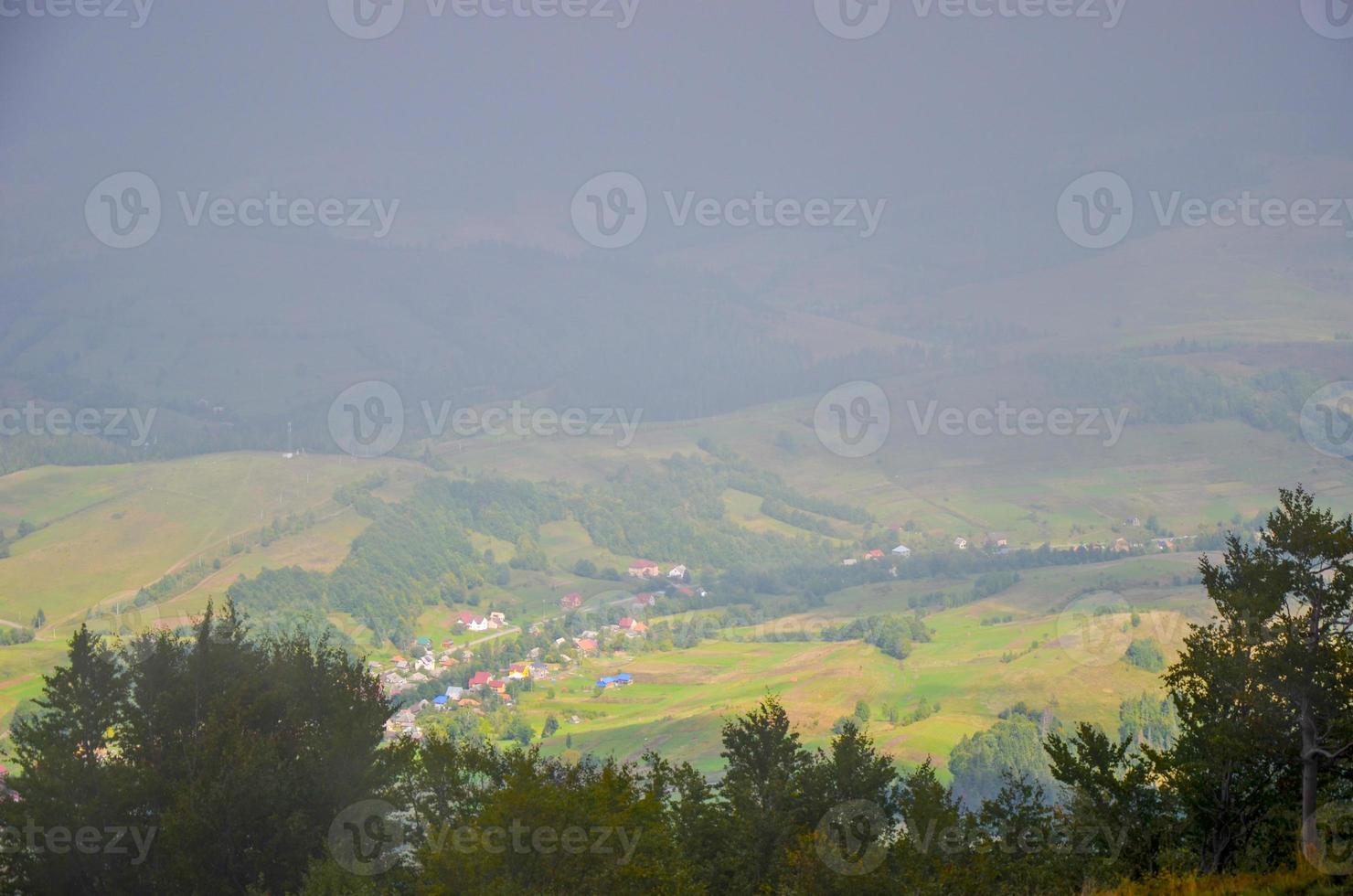 View of village covered in fog at Carpathian mountains photo