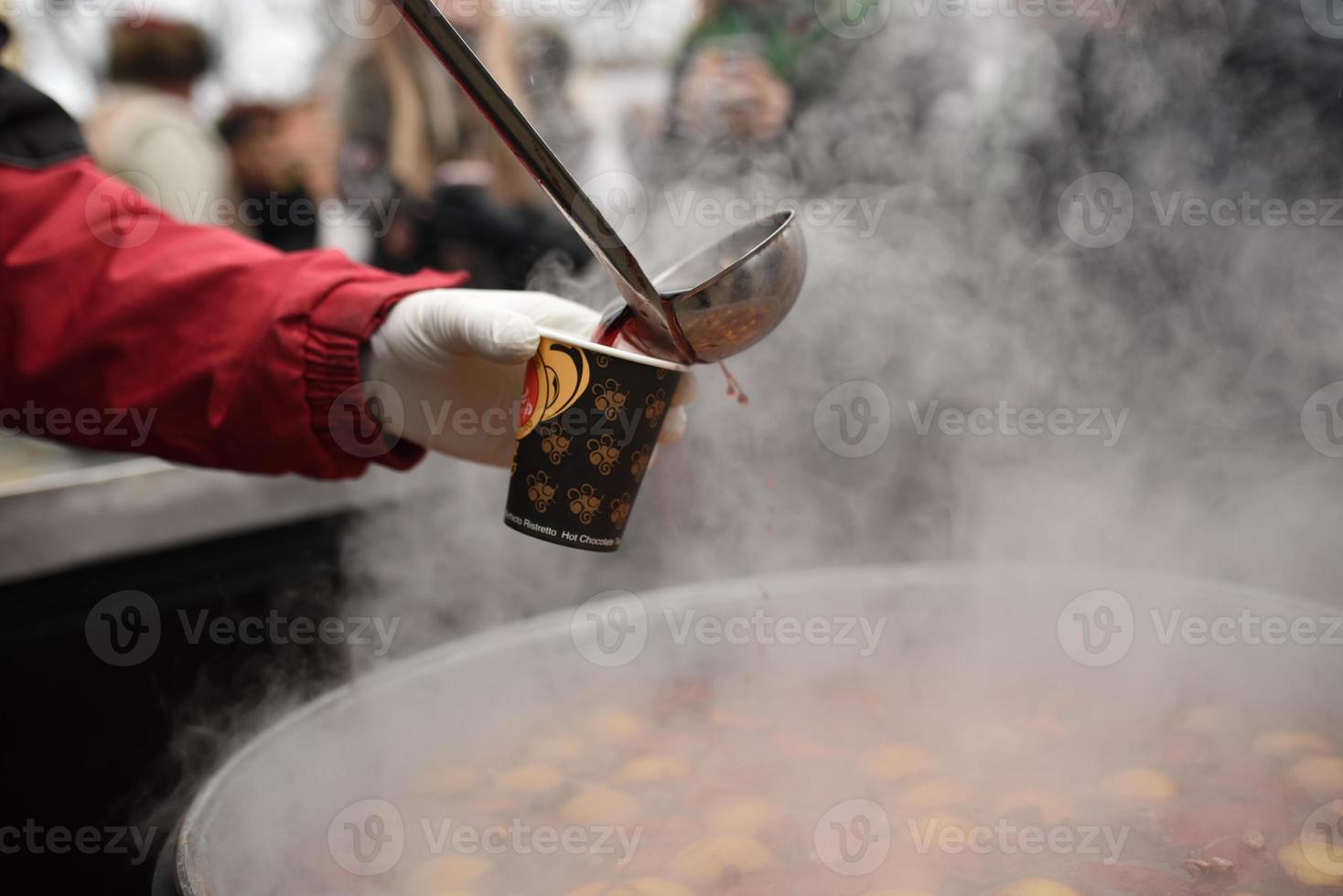 the chef prepares and pours hot mulled wine photo