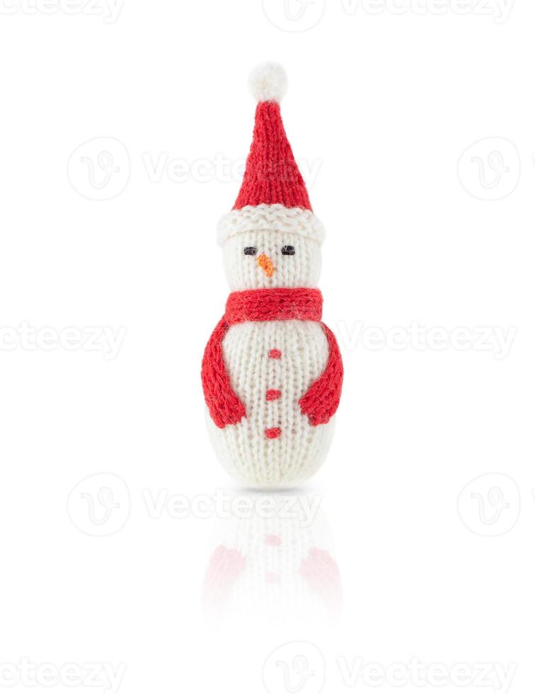 Knitted Christmas snowman in red hat and scarf isolated on white background, with shadow and reflection. photo