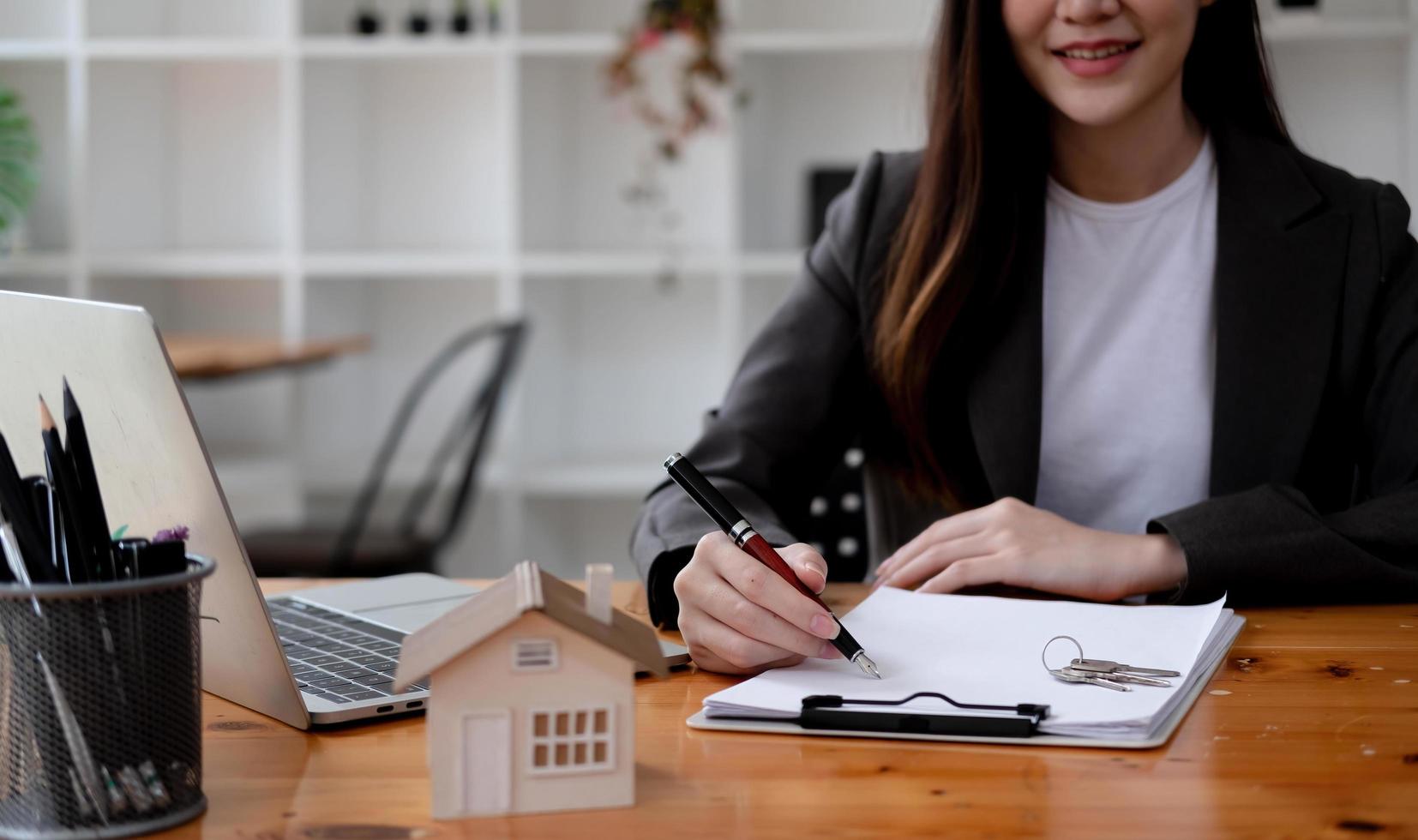 Agente de bienes raíces femenino profesional haciendo un documento de contrato de alquiler en papel en la oficina foto