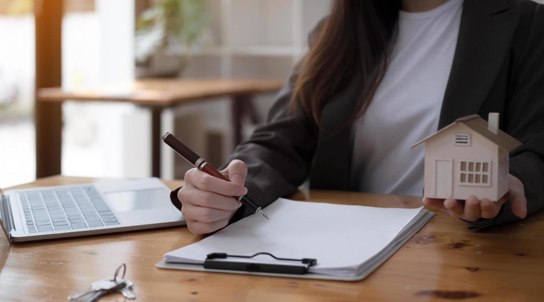 real estate realtor working in the office, reviewing rental contract on papers. Property consultant working in a modern office. photo