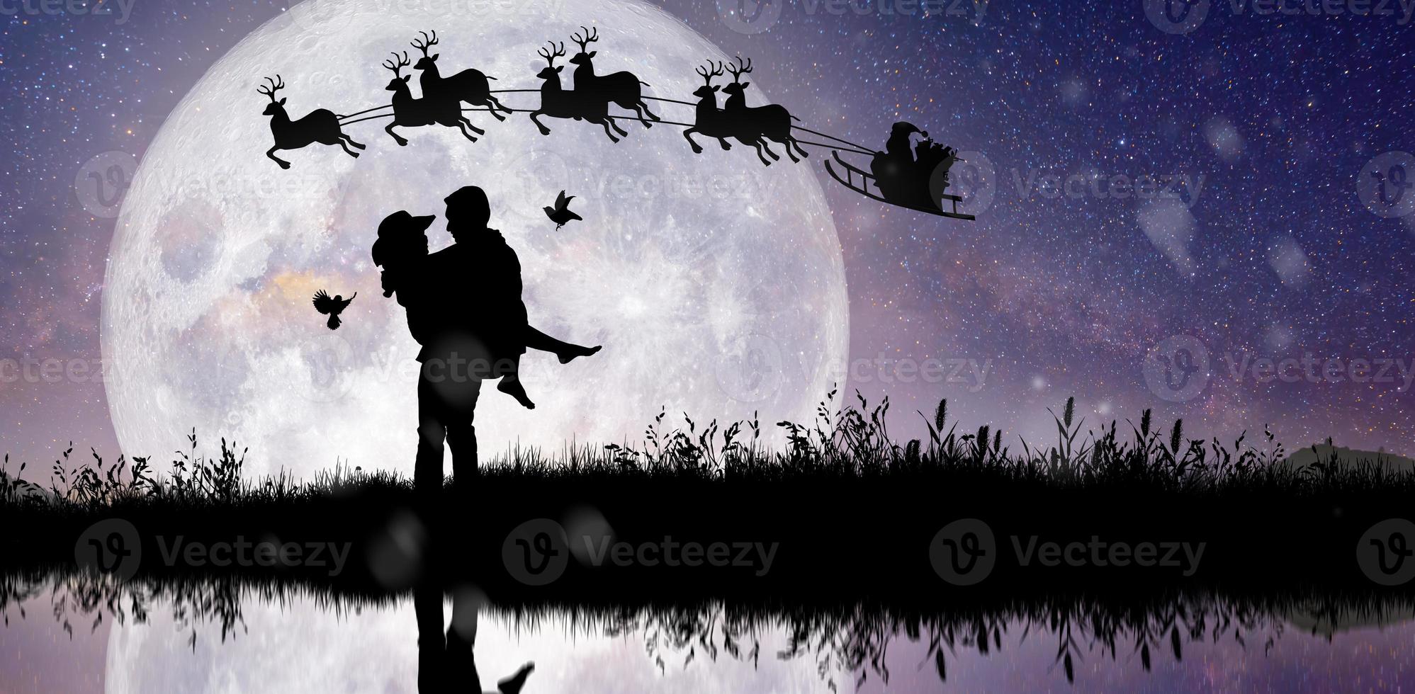 silueta de santa claus en la noche de navidad con pareja bailando bajo la luna llena. foto