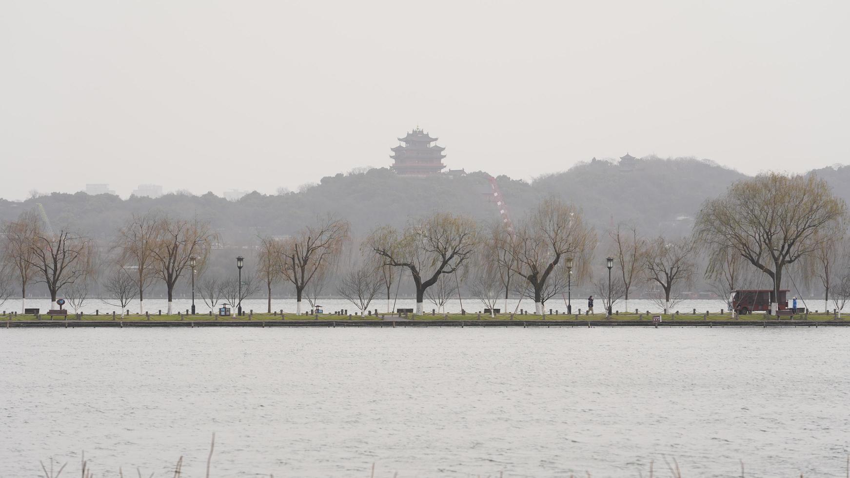 The beautiful Xihu landscape with the old arched bridge and temple tower in Hangzhou of the China in winter photo