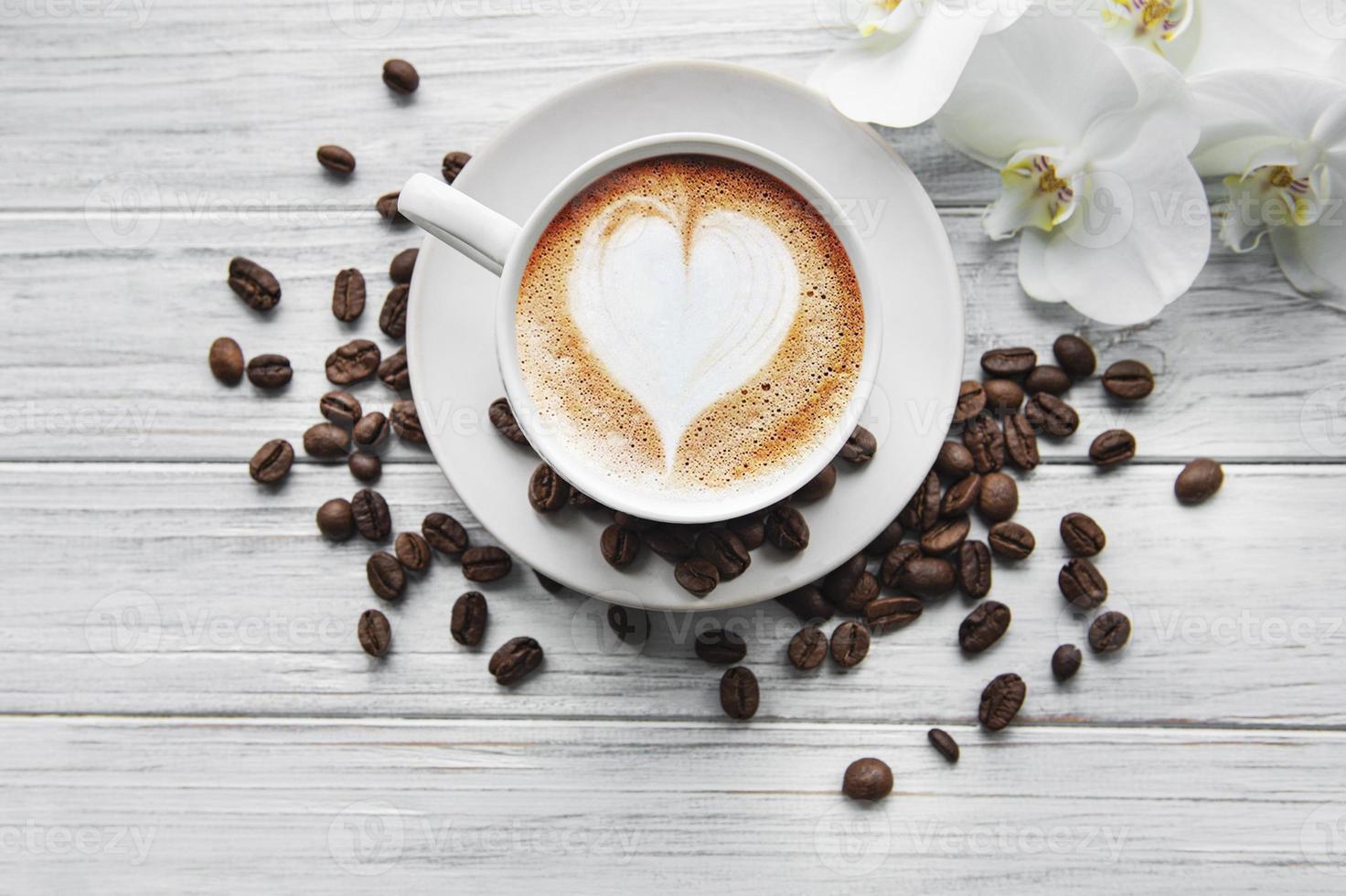 una taza de café con patrón de corazón en una mesa foto