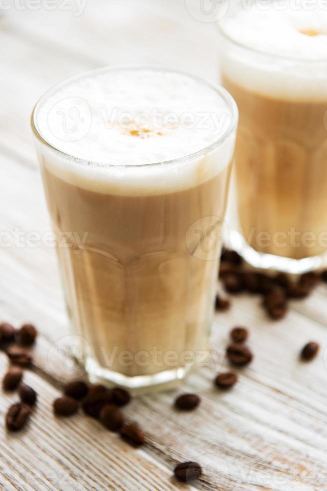 dos vasos de café con leche y granos de café foto