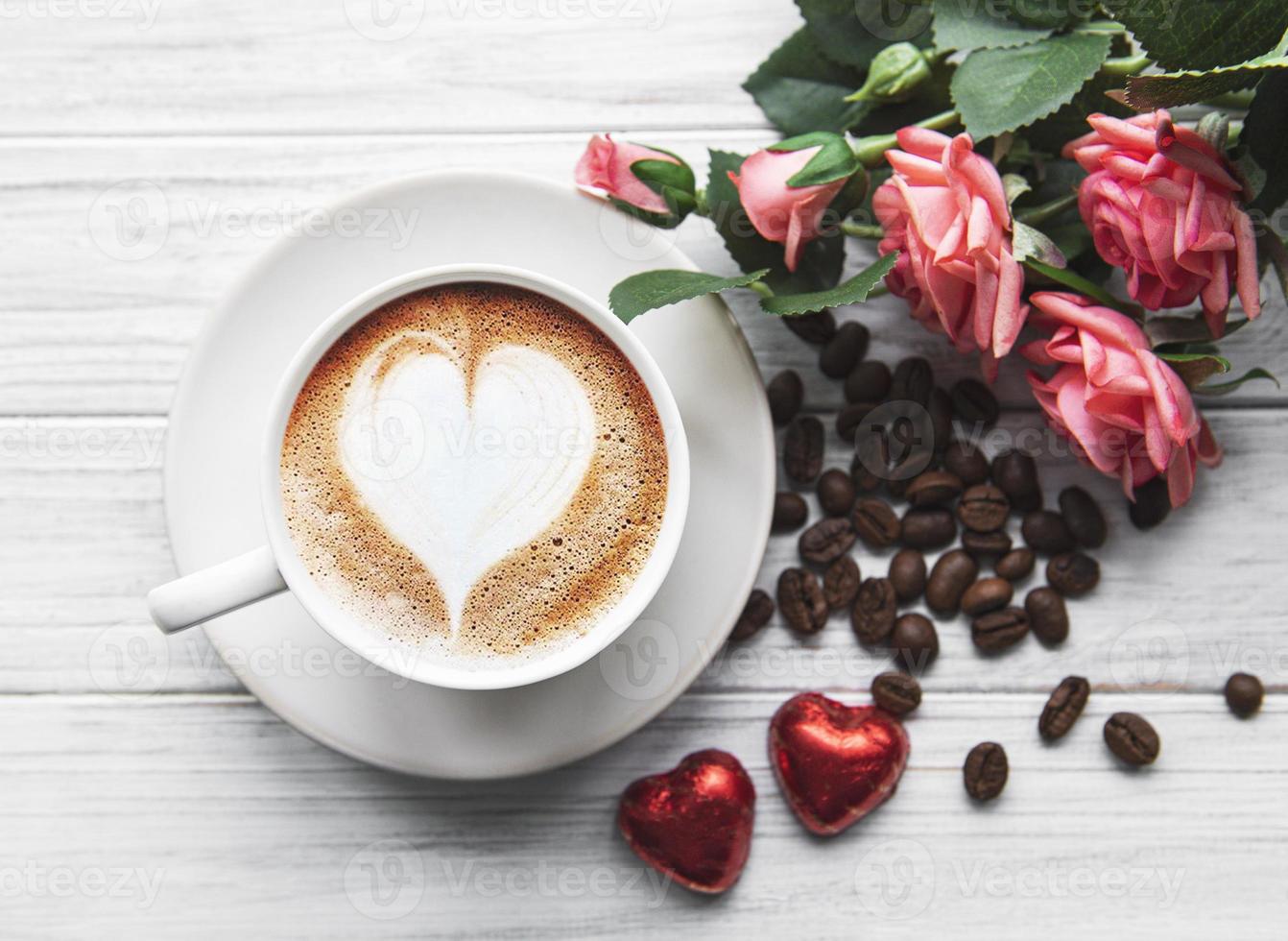 una taza de café con patrón de corazón en una mesa foto