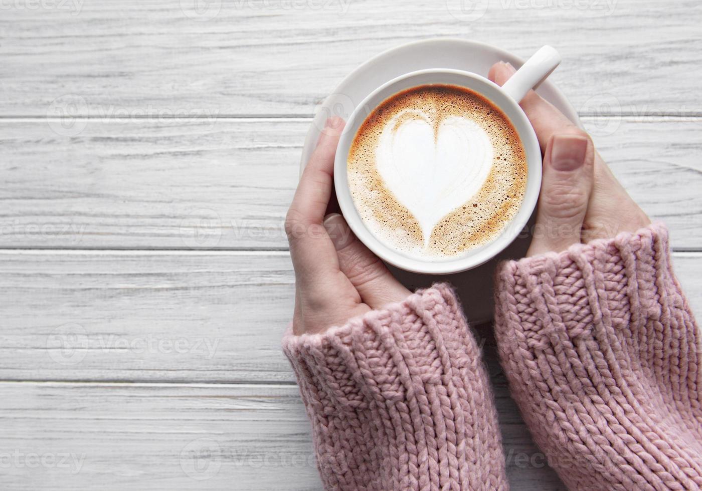 mujer que sostiene la taza de café foto