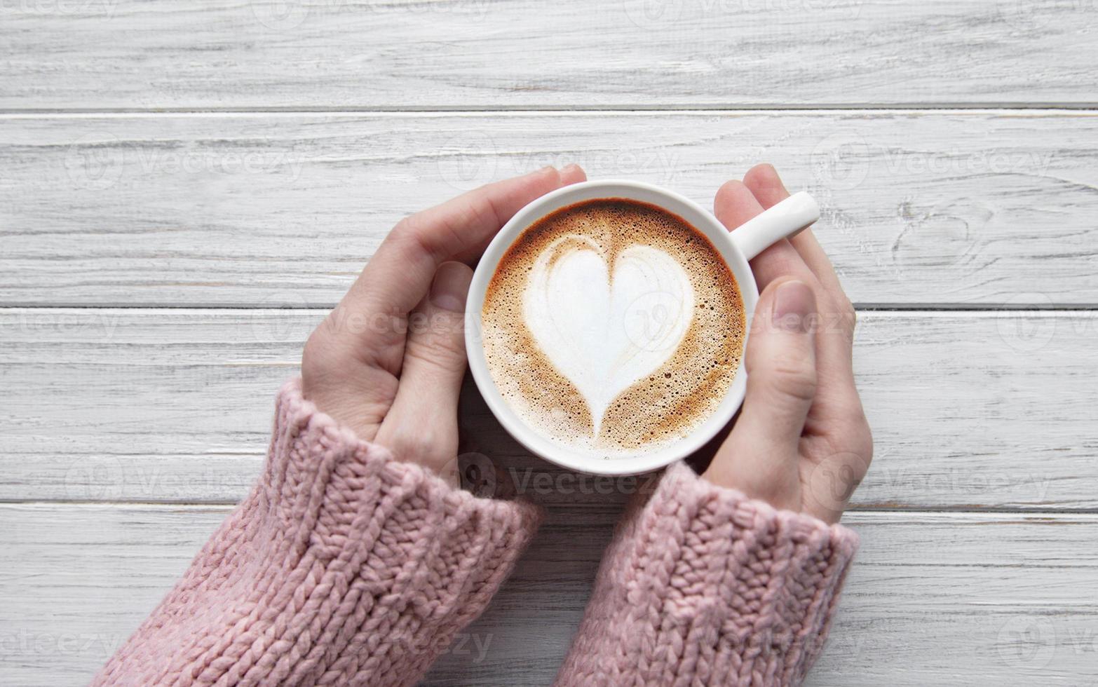 mujer que sostiene la taza de café foto