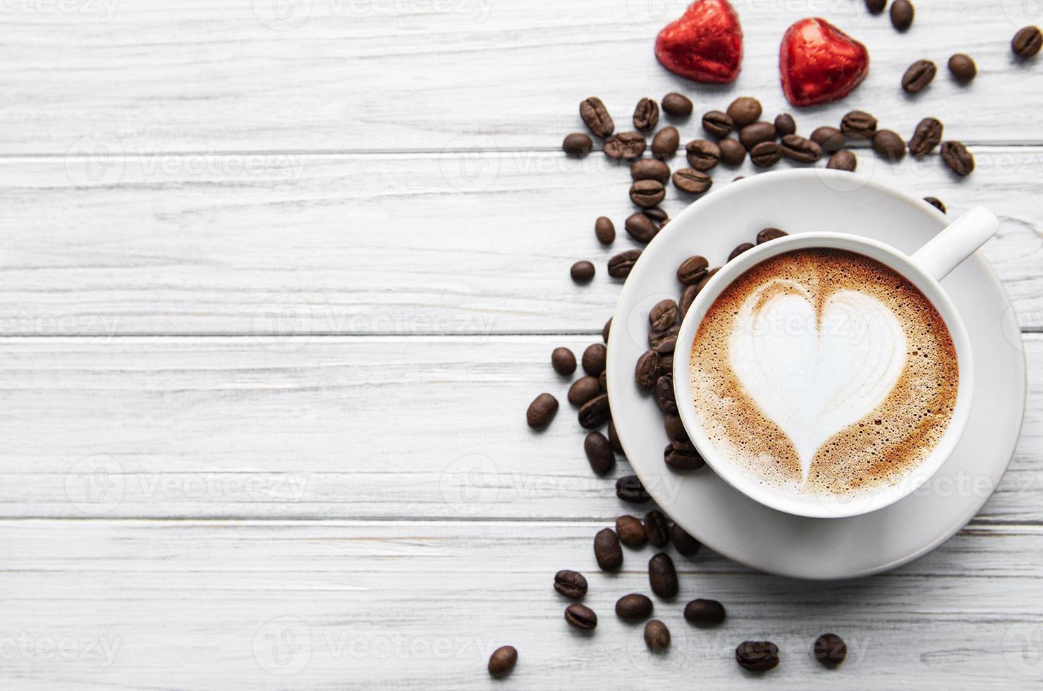 una taza de café con patrón de corazón en una mesa foto