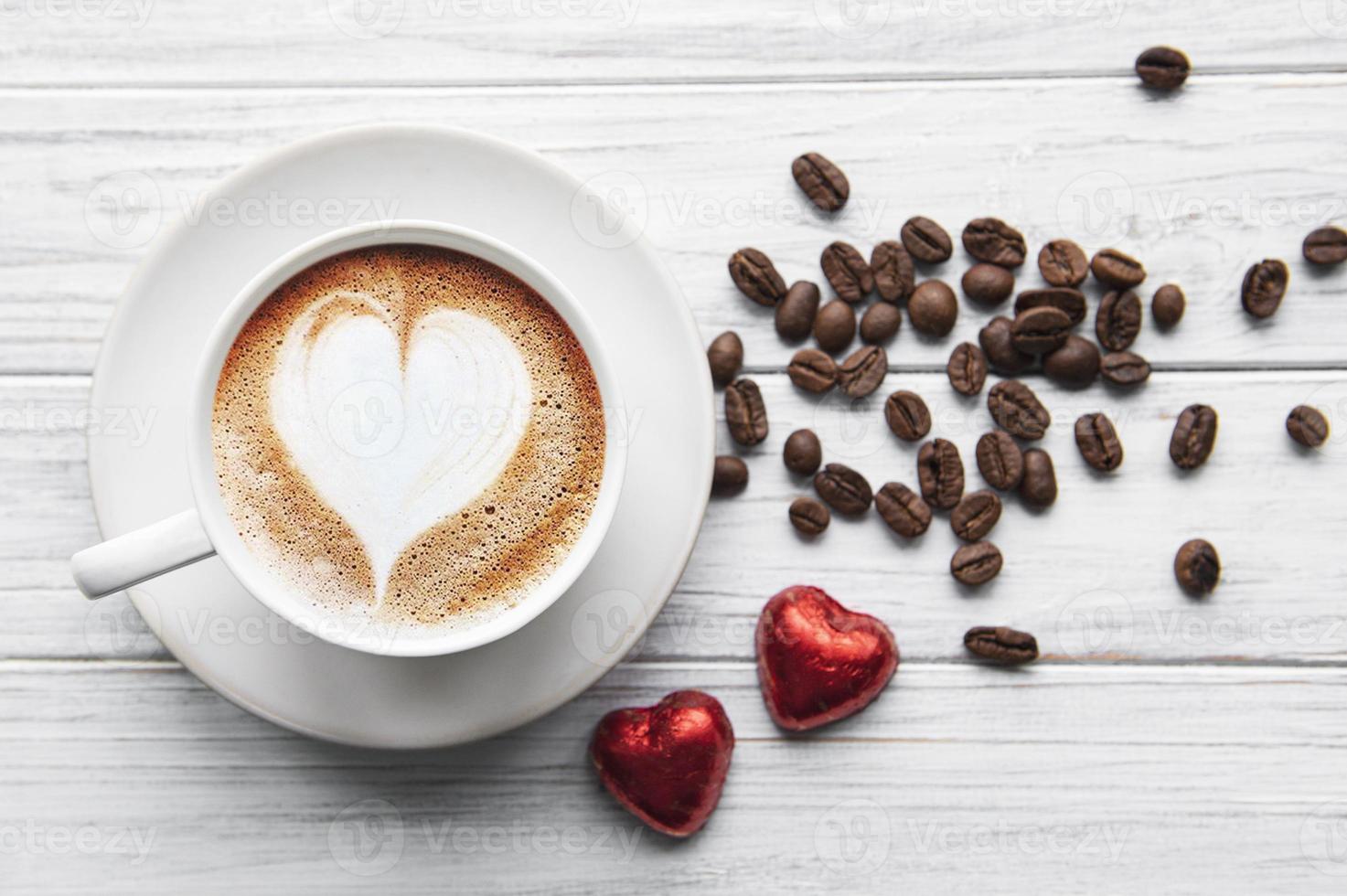 una taza de café con patrón de corazón en una mesa foto