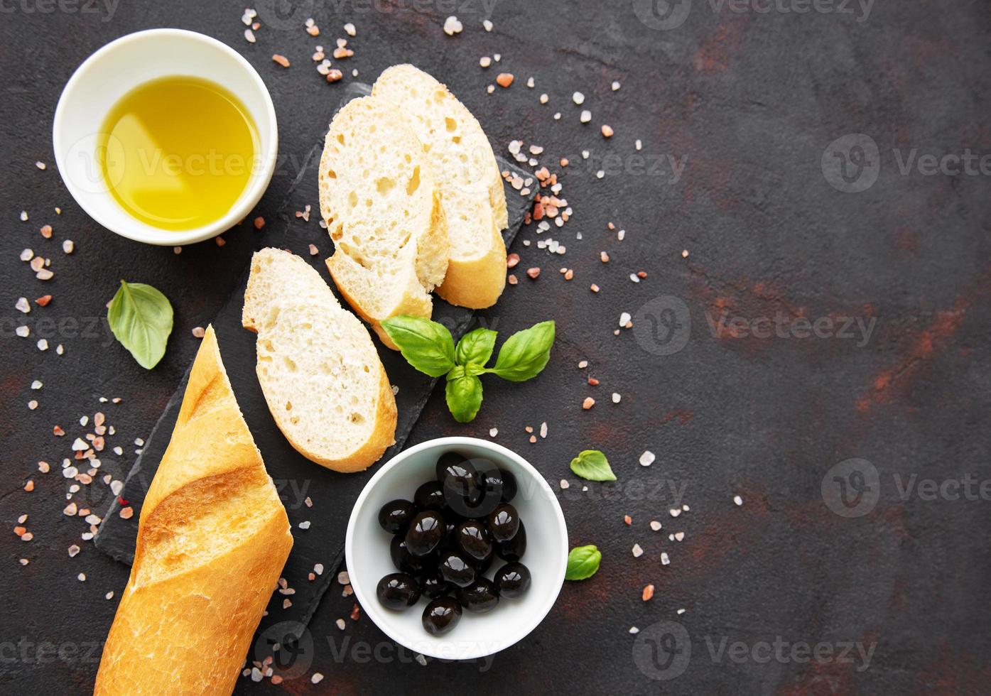 Sliced fresh crusty baguette with olive and spices photo