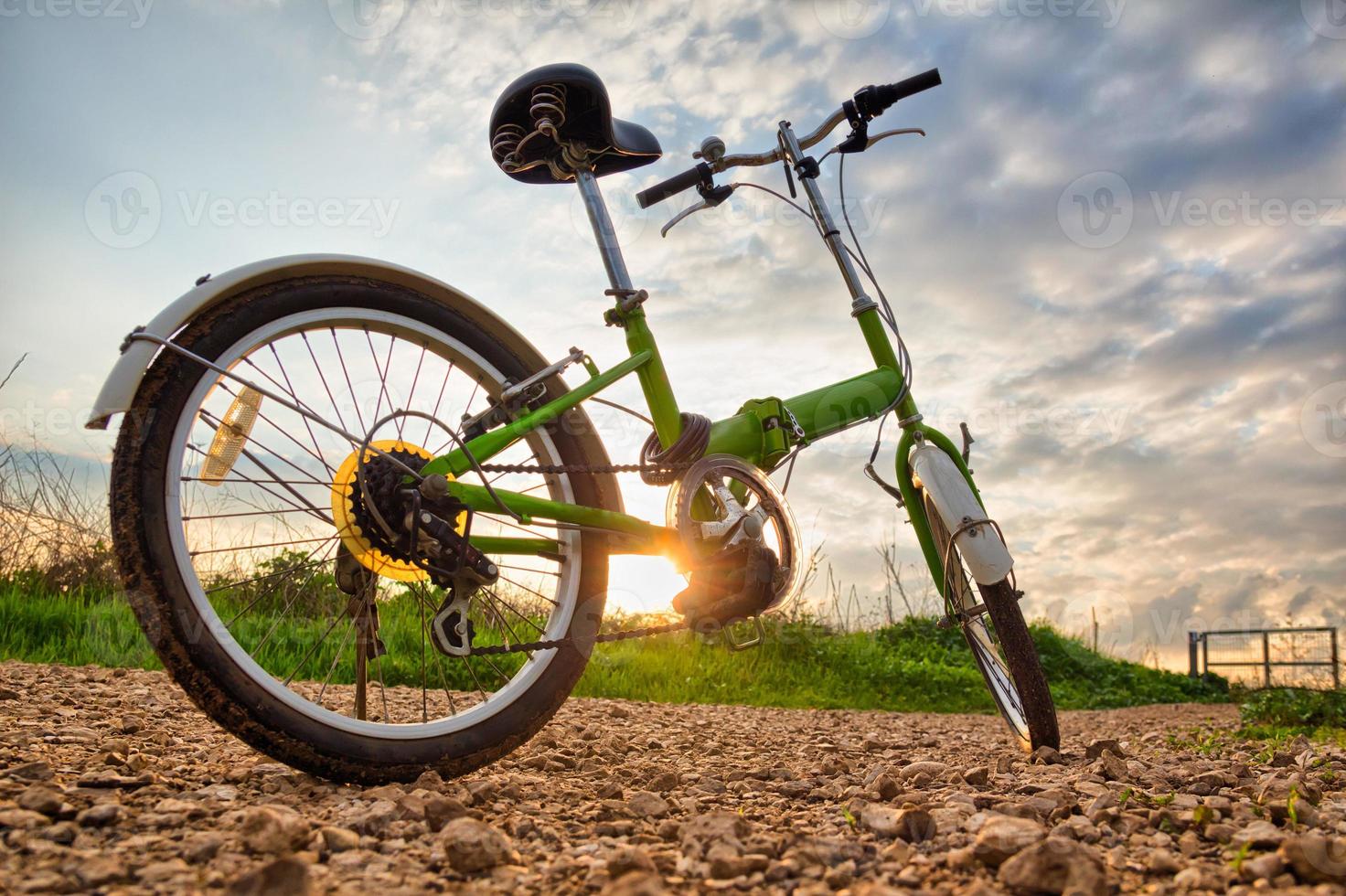 Bicycles parked on a dirt road during sunset photo