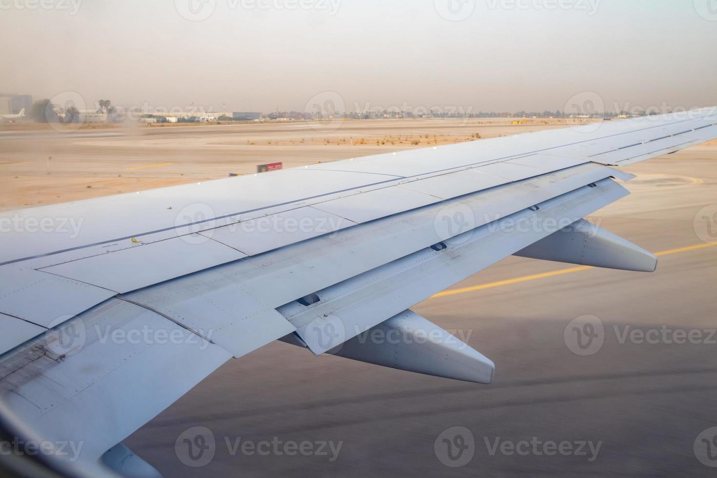 Ala de avión en la pista de aterrizaje en el aeropuerto Ben Gurion al amanecer. foto