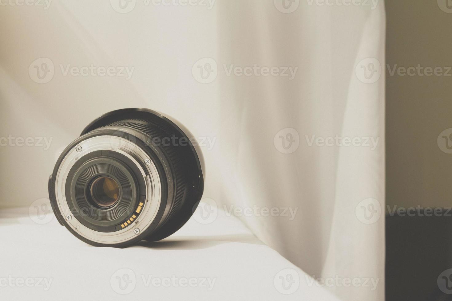 Black camera zoom lens on white cloth photo