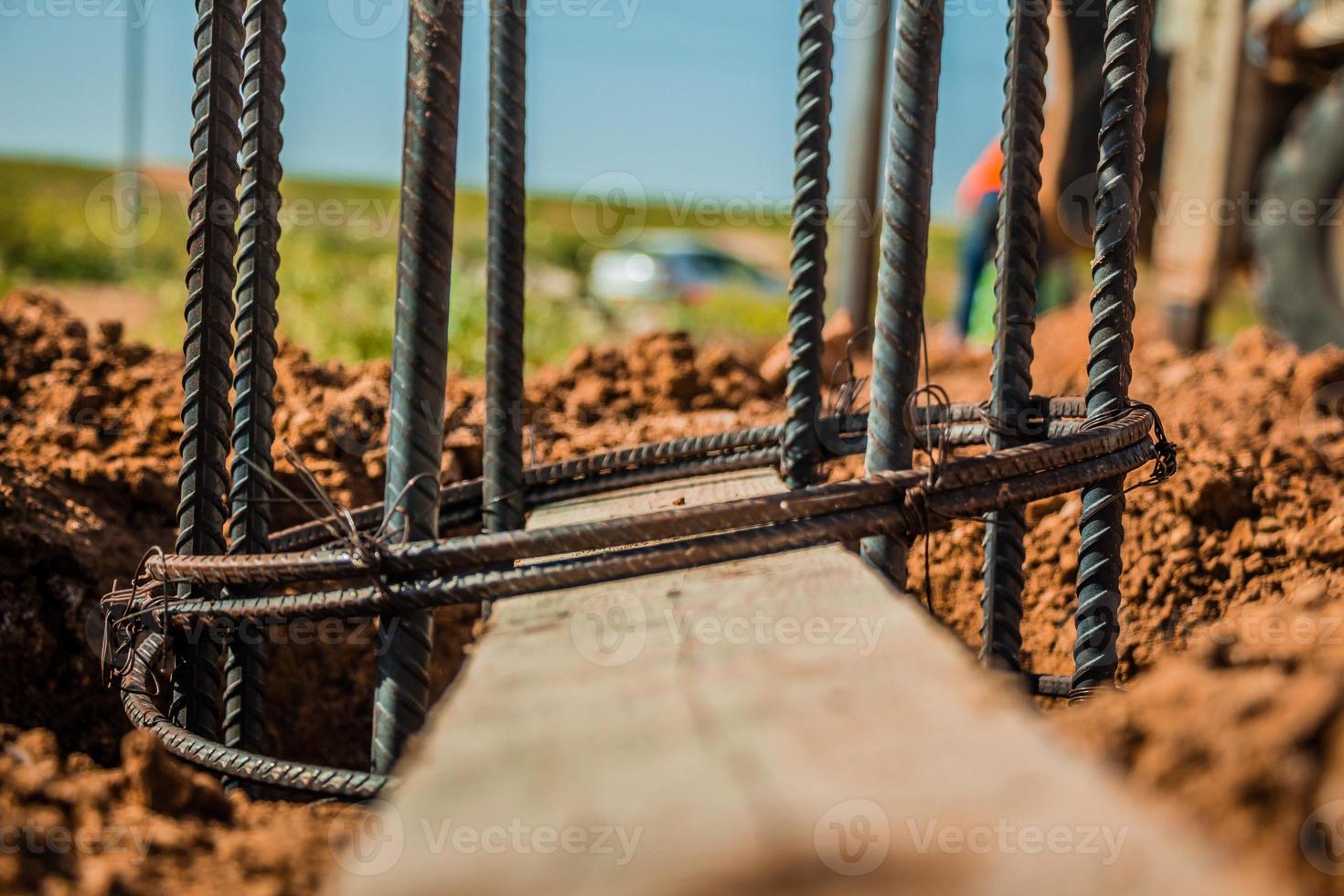 Varilla de acero utilizada para la construcción de postes con hormigón armado en un agujero en el suelo en el sitio de construcción foto