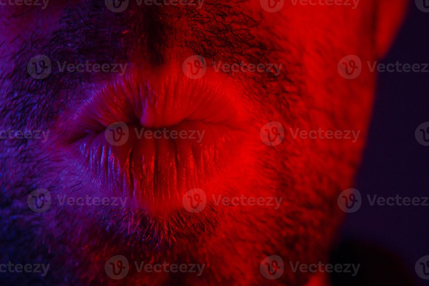 Macro close up on man with seductive facial expression pulled his lips to give a kiss photo