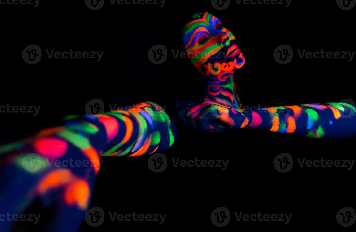 Mujer con arte de maquillaje de polvo fluorescente ultravioleta brillante foto