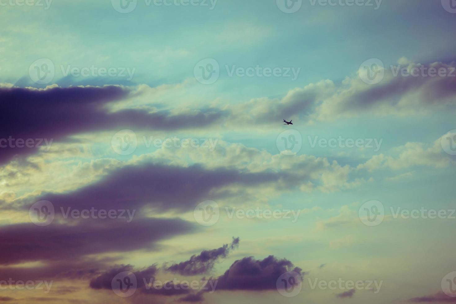silueta de un avión volando en el cielo del atardecer foto