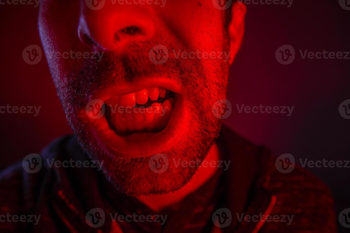 Man with angry facial expression screaming out loud photo