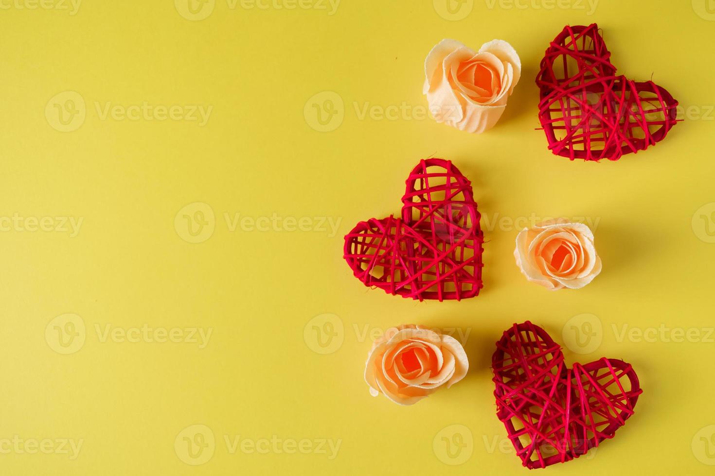 Corazones rojos y flores sobre un fondo amarillo, diseño para el día de San Valentín. foto