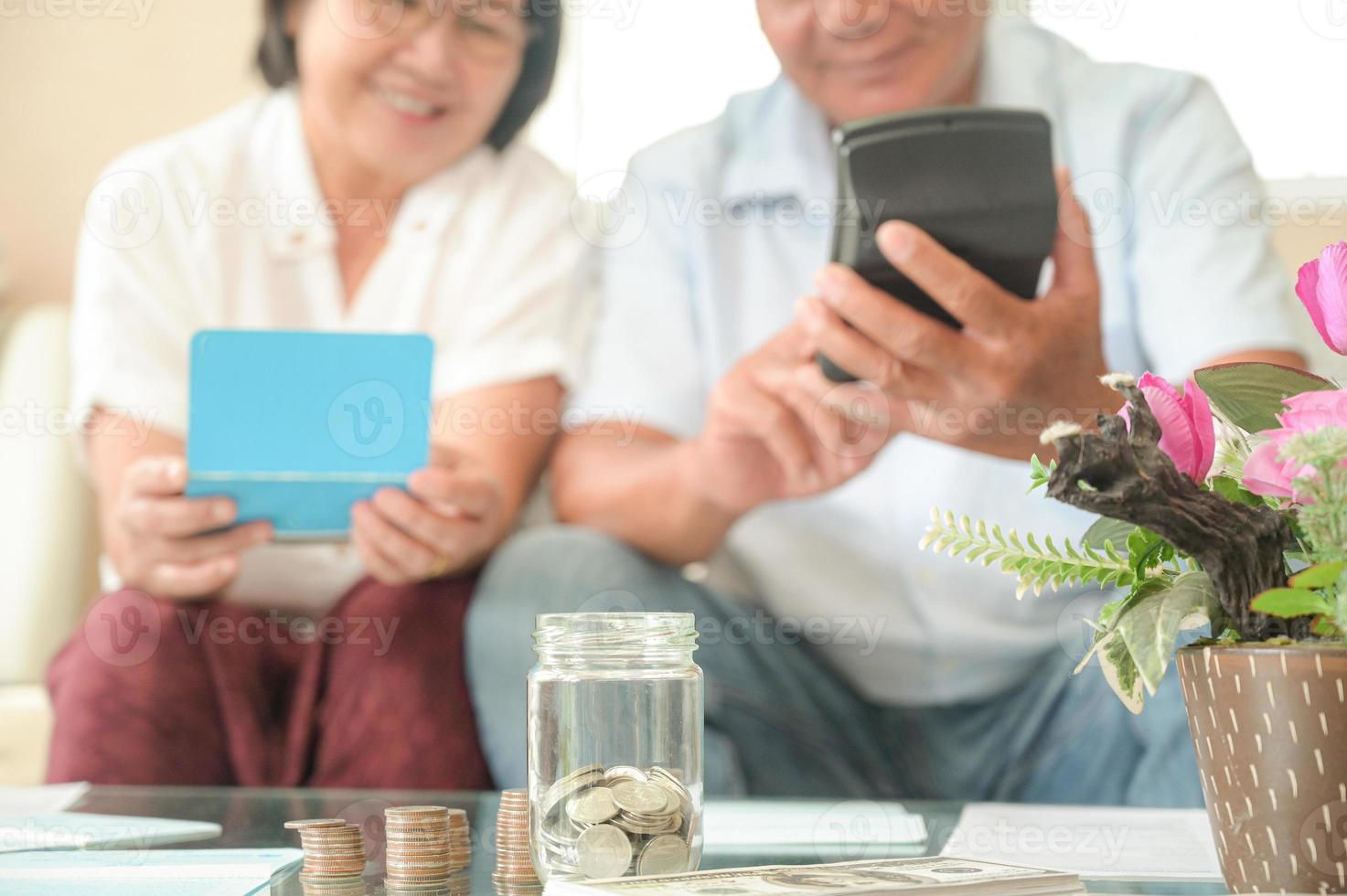 ancianas y hombres asiáticos se sientan en el sofá, hacen planes financieros. foto