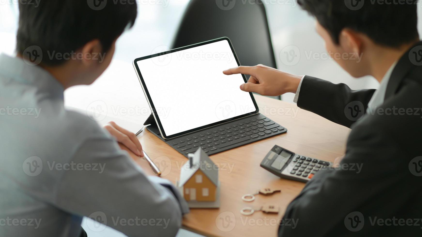 Insurance agents with tablet are introducing real estate insurance programs for customer. photo