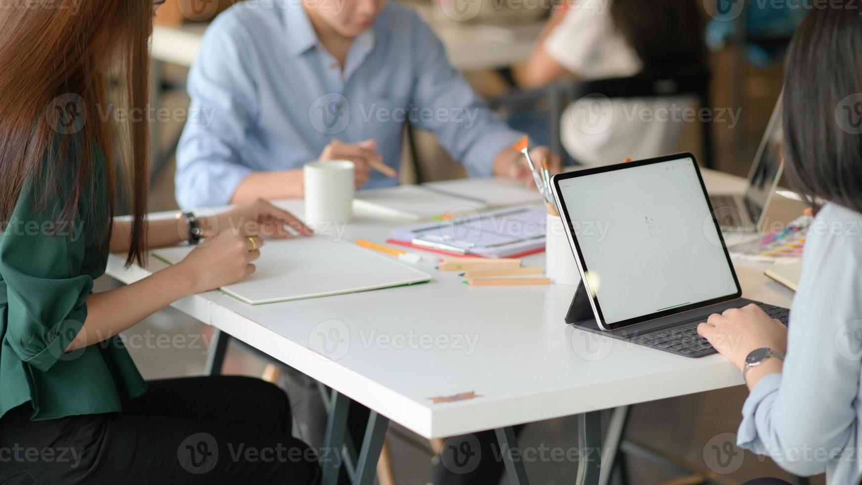 un equipo de diseñadores profesionales está trabajando con teléfonos inteligentes y computadoras portátiles para diseñar aplicaciones. foto