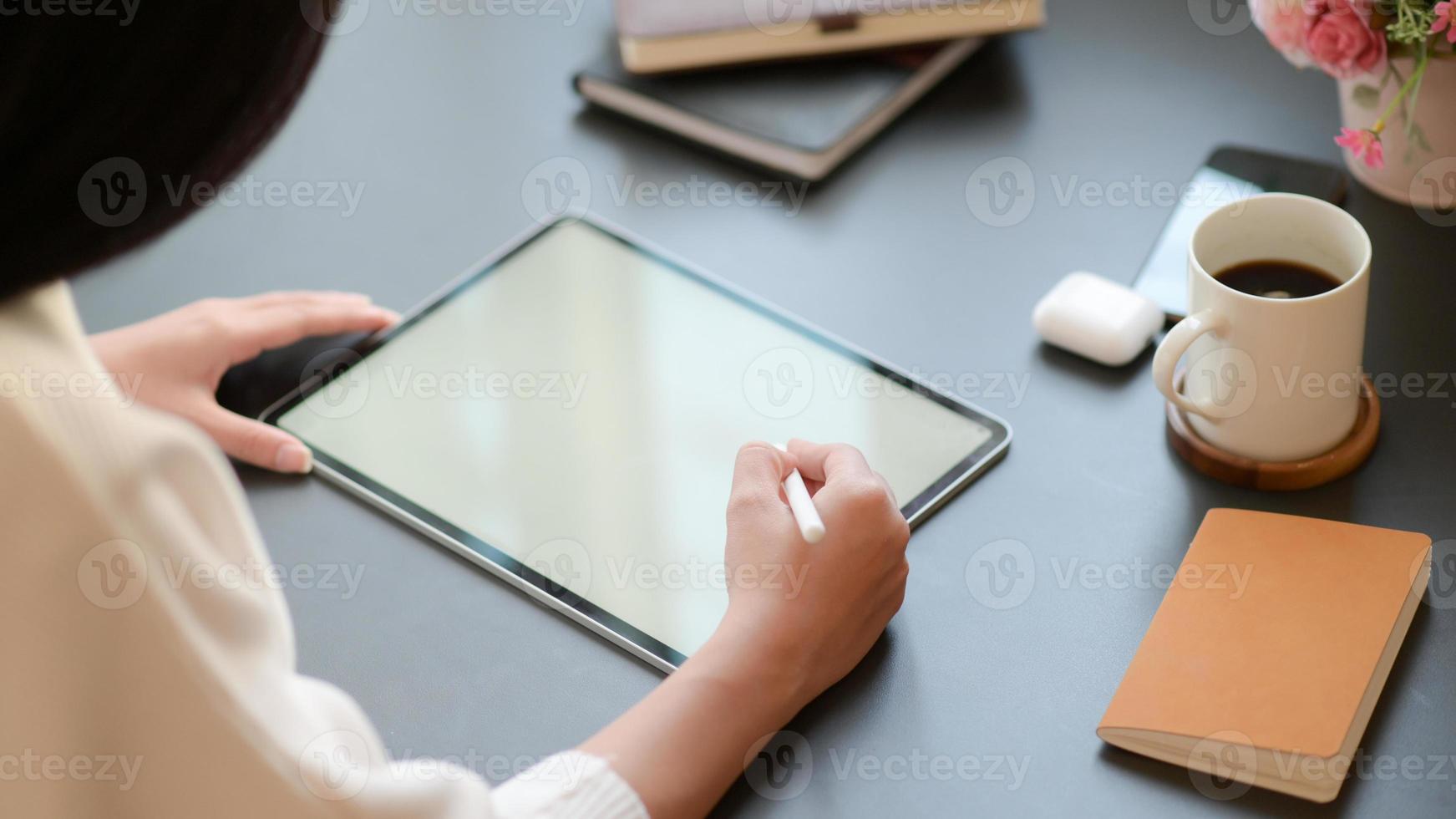 Vista de cerca de una mujer de negocios que está redactando un programa importante con una tableta para su importante proyecto. foto