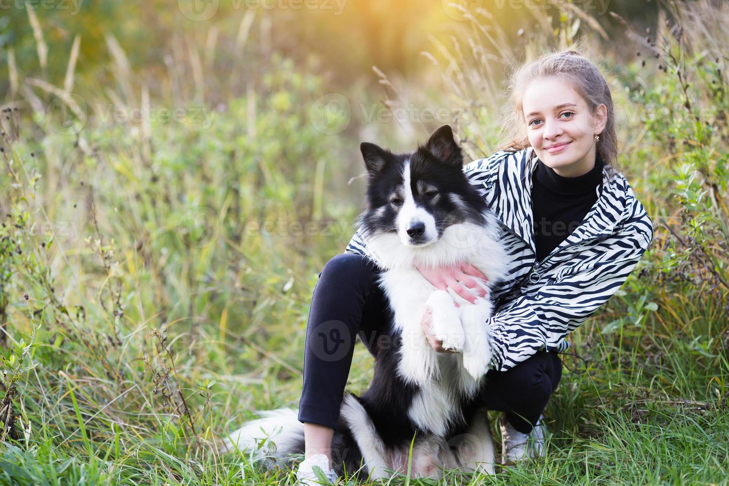 atractiva chica sentada junto a su perro foto