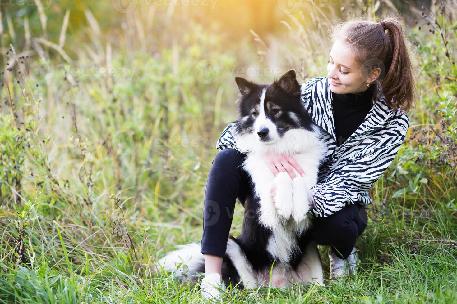 Slender girl sits next to her dog photo