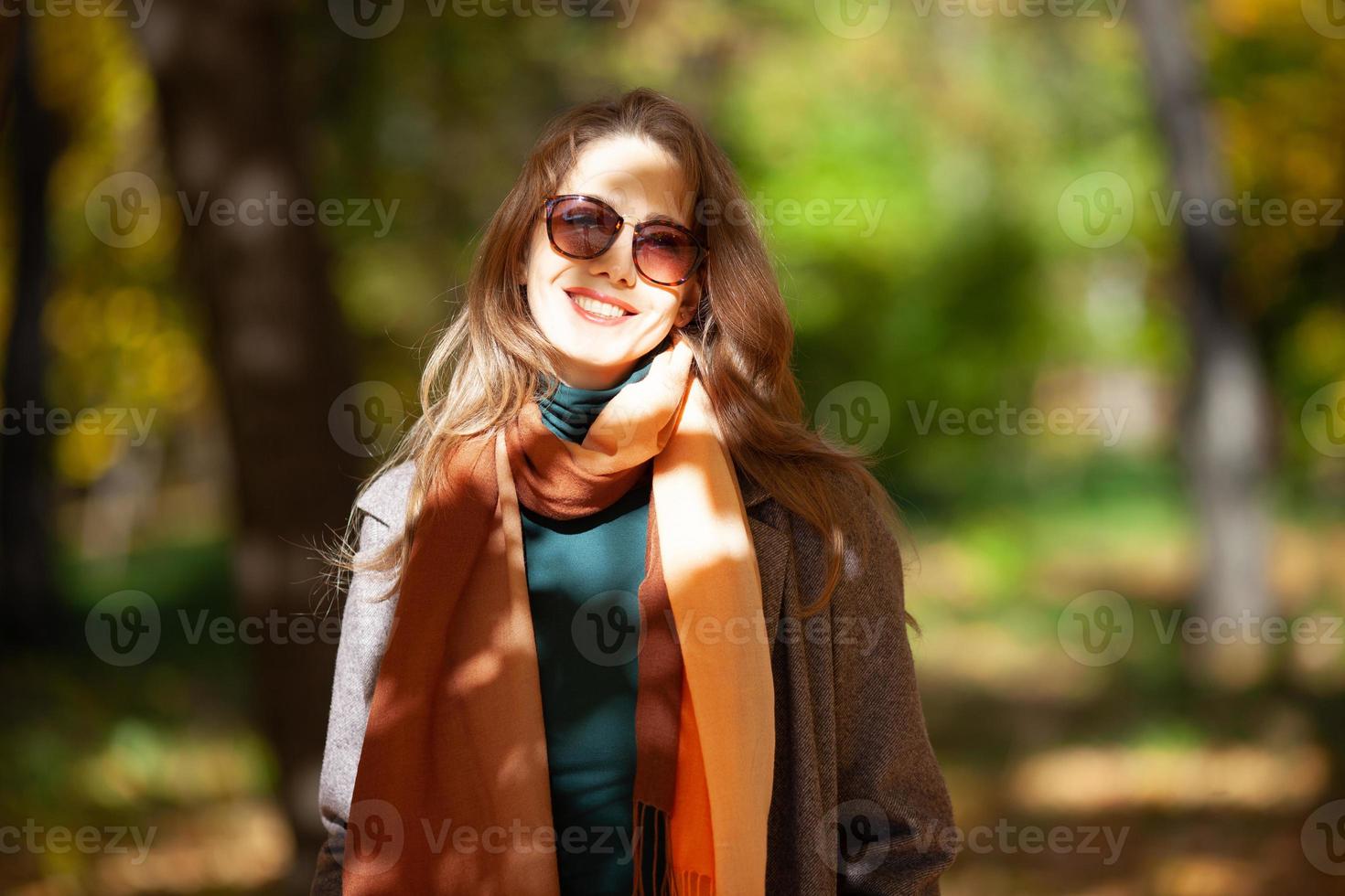 hermosa mujer joven en gafas de sol en el bosque de otoño foto