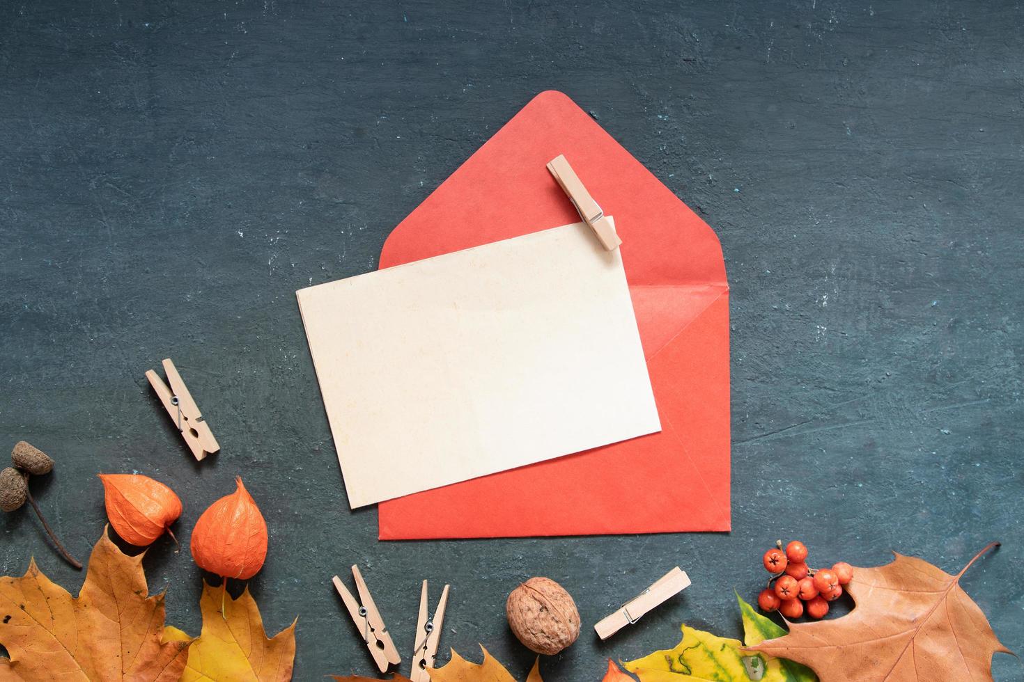 Blank paper sheet Flat lay autumn orange leaves and envelope, physalis on a dark background photo