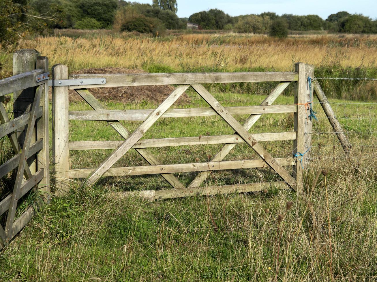 Wooden farm gate in a grassy field photo