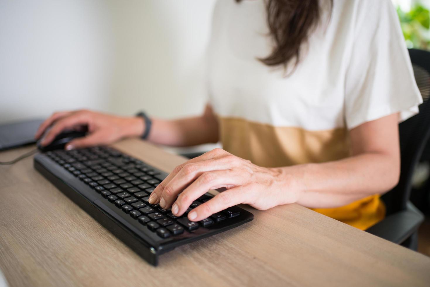 Close up of a woman working at home. Hands on the keyboard, clean desk photo