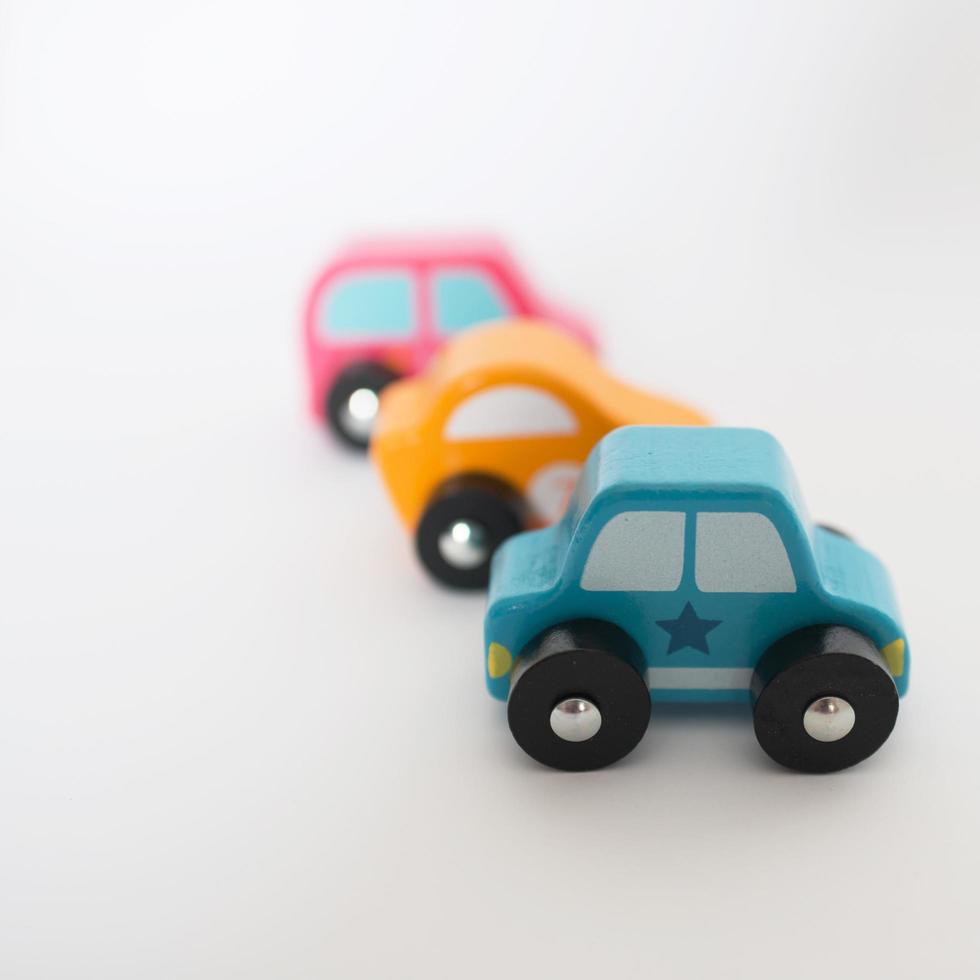 Three colorful toy cars in a row with white background photo