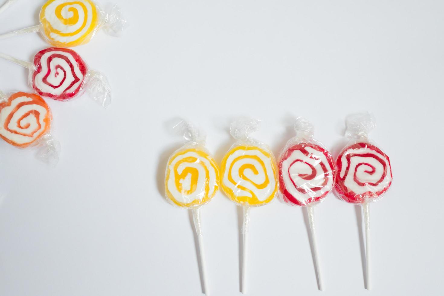 Composition with colorful lollipops and white background photo